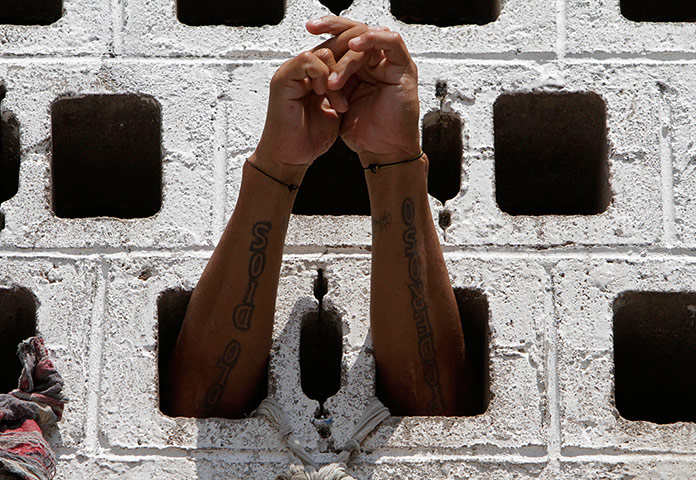 Longer View: A prisoner rests his arms in the wall of his cell