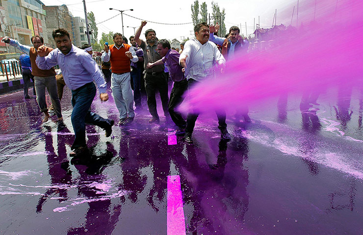 Picture desk live: Government employees are sprayed with colored water by police in Srinigar