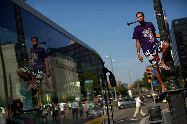 24 hours in pictures: A demonstrator encourages drivers to blow their horns in front  Caixa Bank