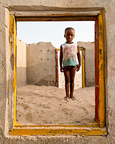 We Face Forward: Seven year-old Collins Kusietey in the remains of a destroyed house