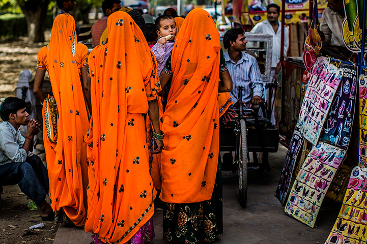 24 hours in pictures: A boy eats an ice cream as he is carried past carts