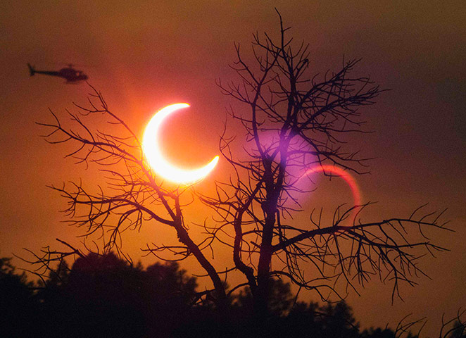 Wildfires in the US: A helicopter flies past the solar eclipse near Payson