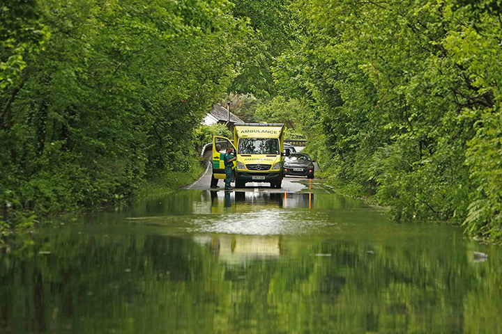 Wales floods: An emergency vehicle stops at a flooded road in Machynlleth