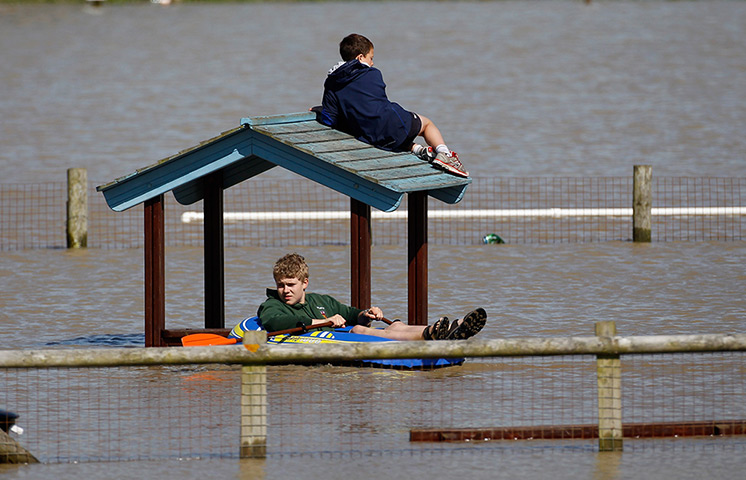 Wales floods: Children play in a flooded play park in the seaside village of Borth 