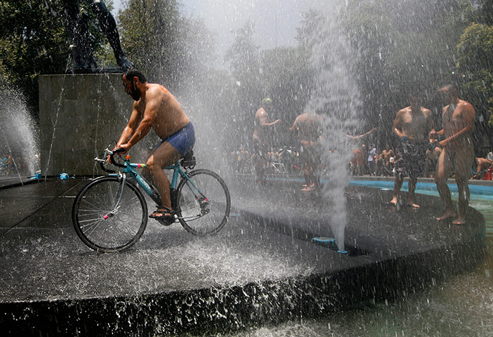 Nude Cyclists: Mexico City, Mexico: A man rides his bike in a public fountain 