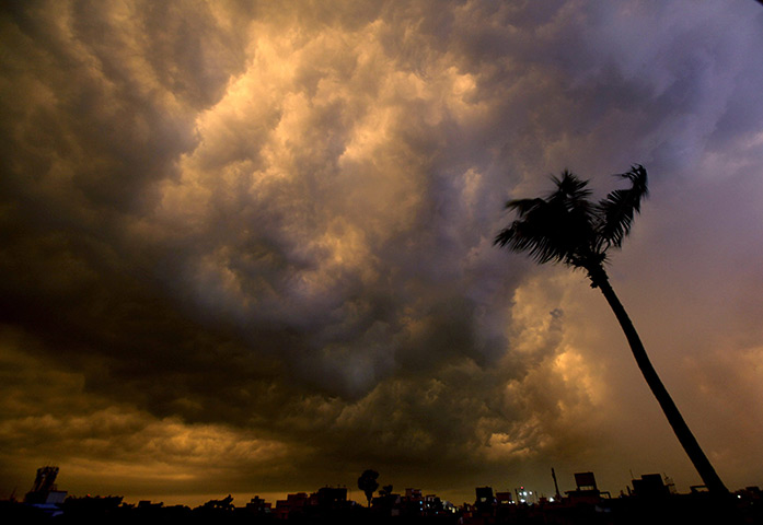 24 hours: Kolkata, India: Dark rain clouds illuminated by the setting sun 