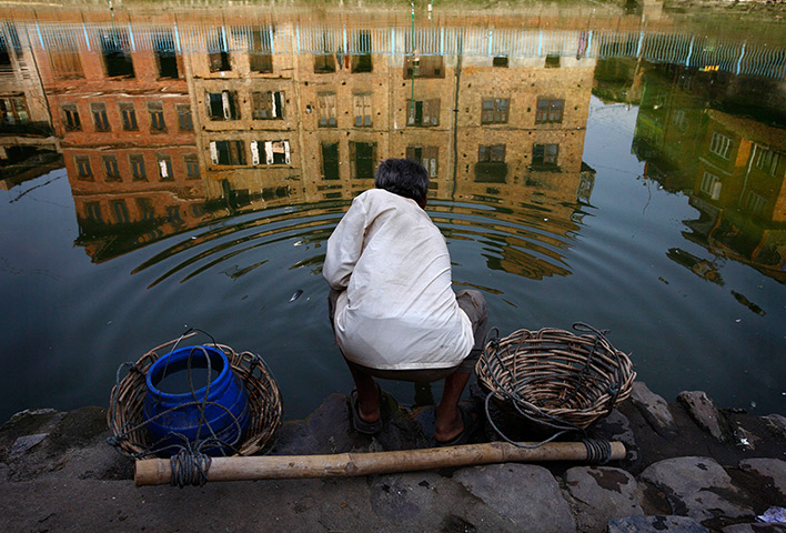 24 hours: Bhaktapu, Nepal: A man fills a container with water in the ancient city