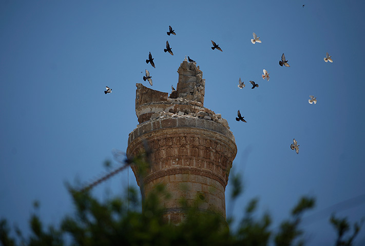 24 hours: Ariha, Syria: Birds fly over the destroyed minaret of a mosque 