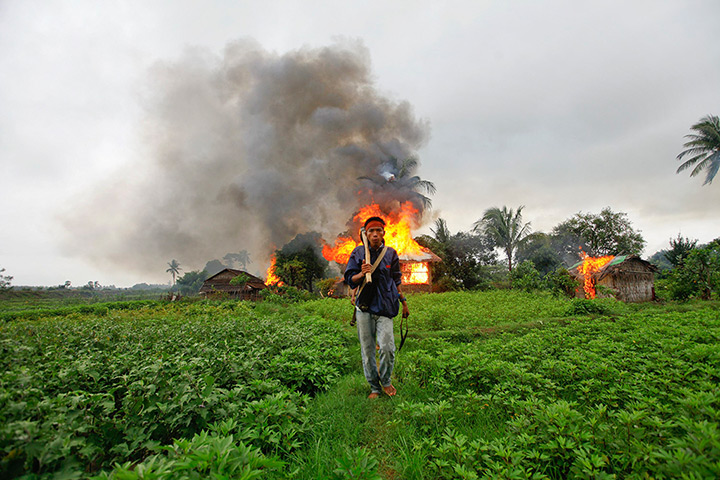 24 hours: Sittwe, Burma: An ethnic Rakhine man holds homemade weapons 