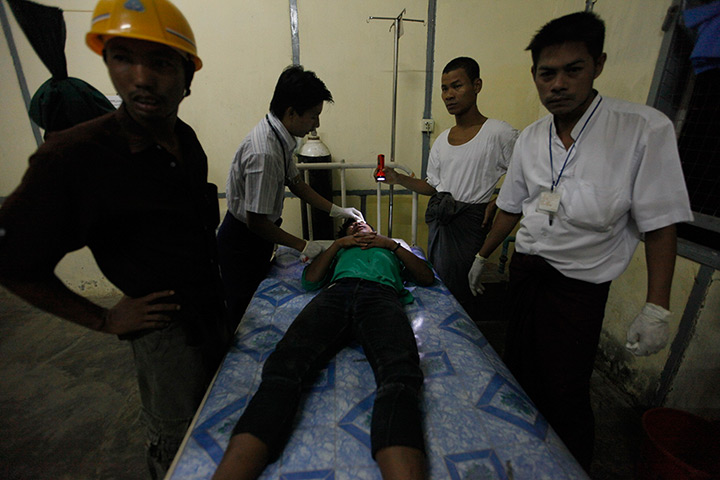 Burma violence: A Buddhist man injured in clashes is treated in hospital in Sittwe