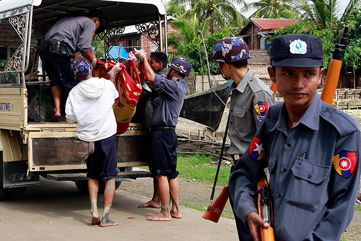 Myanmar violence: Policemen carry an unidentified body to a truck in Sittwe