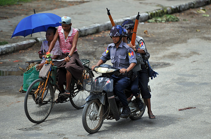 Burma violence: Policemen patrol with rifles on the streets of Sittwe