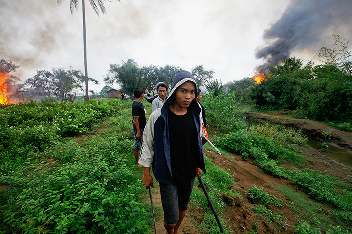 Burma violence: An Ethnic Rakhine man holds homemade weapons in Sittwe