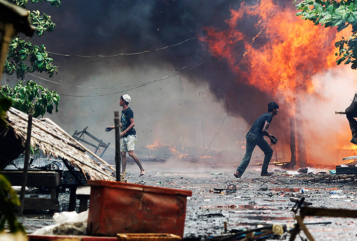 Burma violence: Rohingya men are seen among houses set on fire during fighting