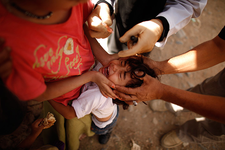 24 hours in pictures: A girl cries as she receives a Polio vaccine shot in Sanaa