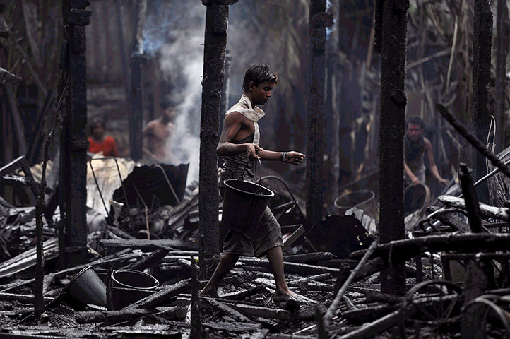 Picture desk live: A resident walks through the remains of burned house in Sittwe, Burma