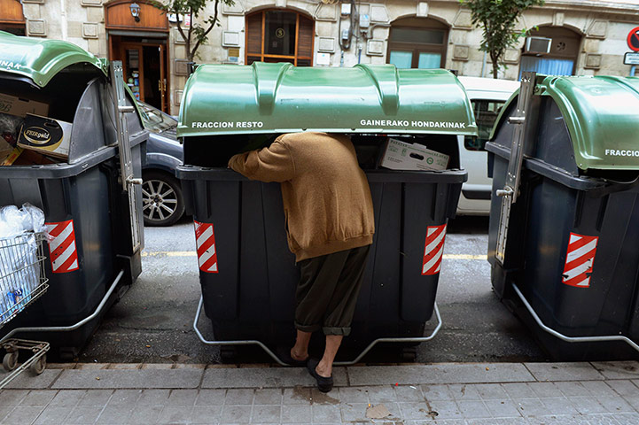 Picture desk live: Man searches for food in container outside a supermarket in central Bilbao