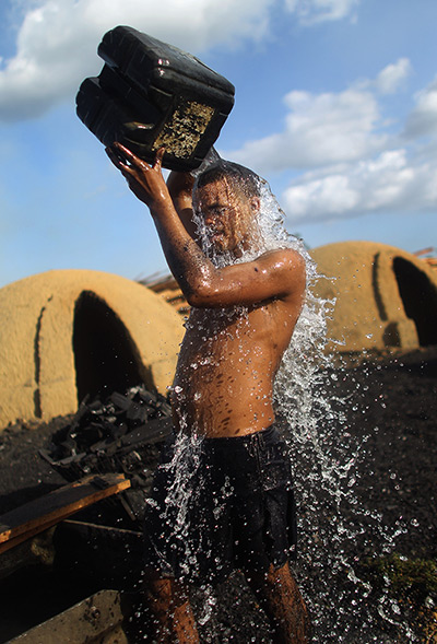 Amazon deforestation : A worker douses himself with water while taking a break