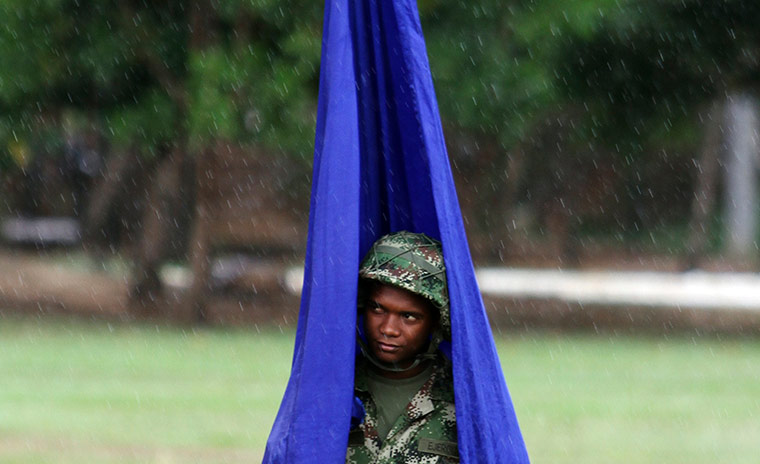 Picture Desk Live: A soldier attempts to take shelter from the rain