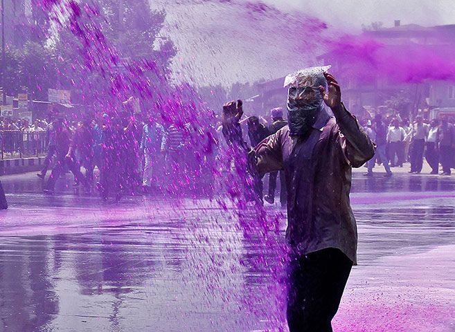 Picture Desk Live: A protestor wears a plastic bag to shield himself from dyed water cannon 