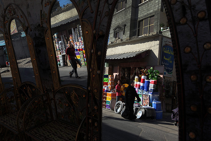 24 hours in pictures: Palestinian people are reflected in mirrors for sale