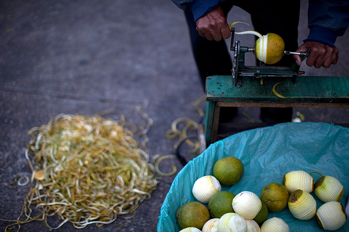 24 hours in pictures: A street vendor peels oranges at a public park in Guatemala City