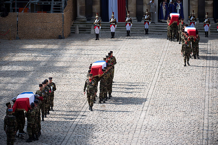 24 hours in pictures: Brothers in arms carry  the coffins of their comrades, Paris