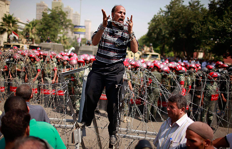 Picture Desk Live: Protester shouts as he stands on top of a barricade in Cairo