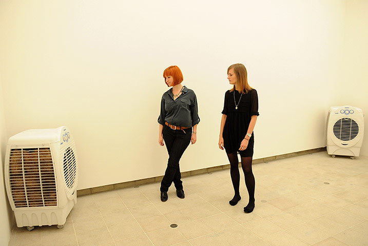 Invisible Art: Two Women in gallery space look at heater