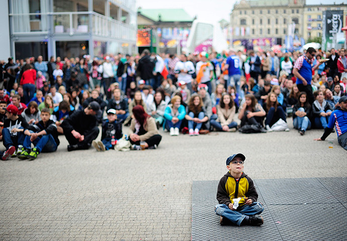 24 hours in pictures: A young boy watches the UEFA EURO 2012 match, Poland