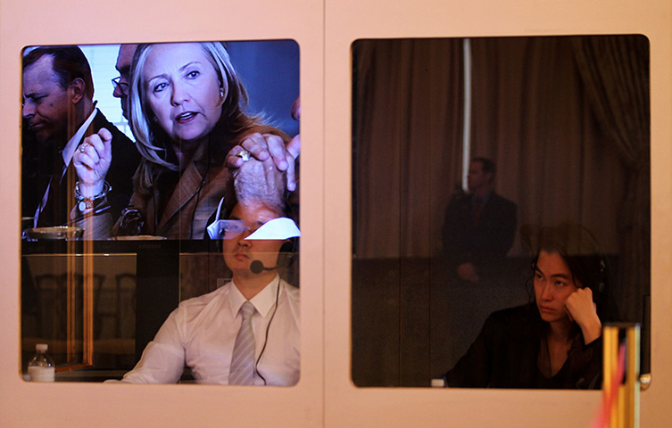 24 hours in pictures: Hillary Clinton's image is reflected on the window of a translator booth