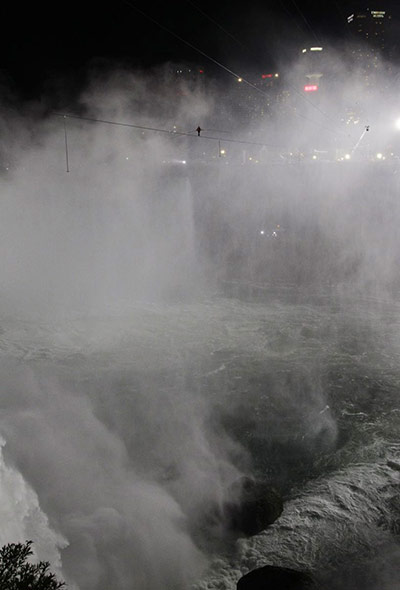 niagara falls tightrope: The tightrope walker above the roiling falls, with high-rises