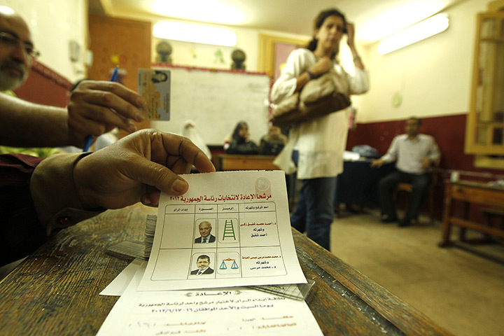 Egypt elections day 2: An Egyptian electoral official holds a voting ballot 