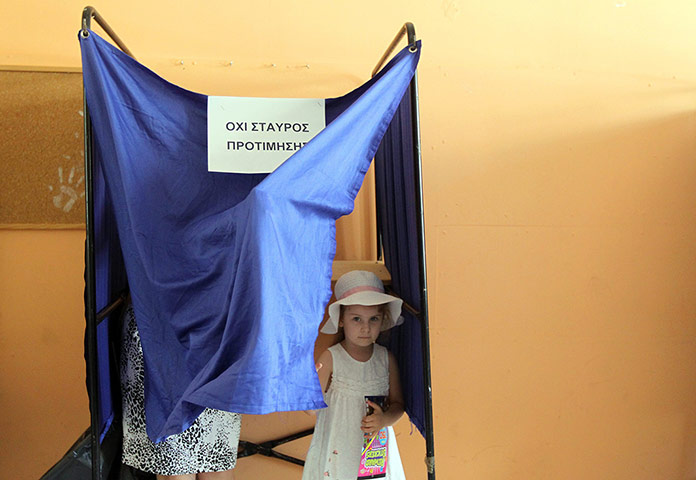 Greek elections: A girl goes to vote with her mother in a polling station in Athens