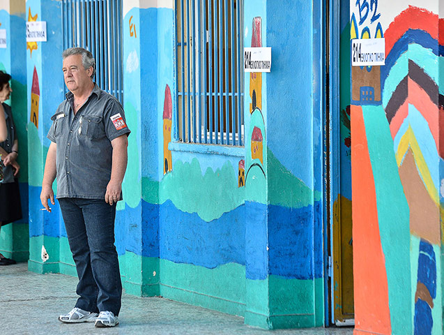 Greek elections: A member of Greek Communist party stands outside a polling station
