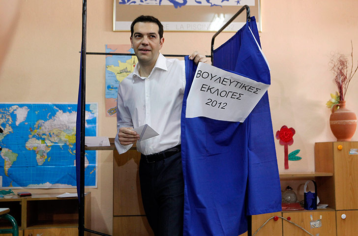 Greek elections: Alexis Tsipras exits from a polling booth with a ballot in his hand