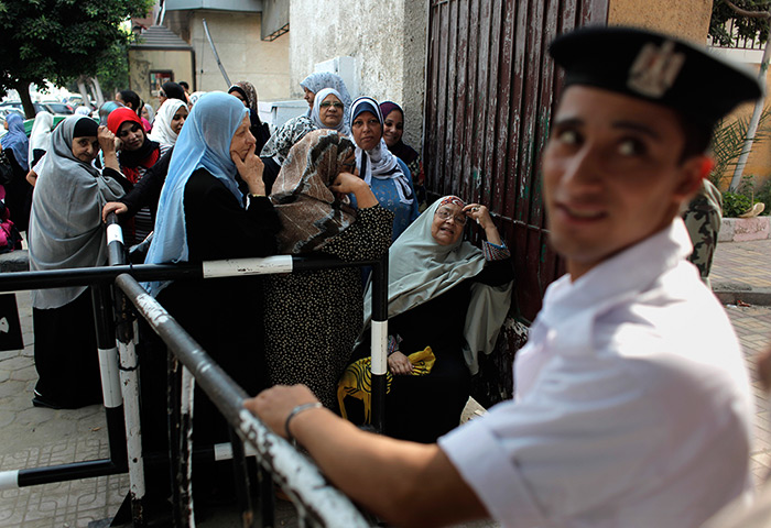 Egypt elections day 2: An Egyptian policeman stands guard outside a polling station in Cairo