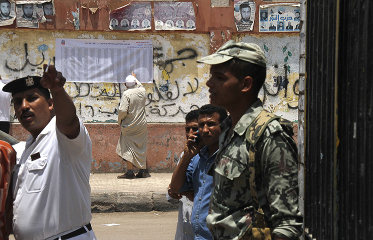 Egypt elections day 2: An Egyptian voter checks for his name on a list outside a polling station