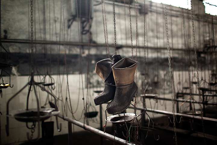 24 hours in pictures: Boots hang in a changing room in a closed Santiago mine