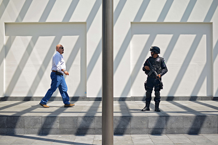 24 hours in pictures: A federal policeman stands guard as a man walks past at G20 summit