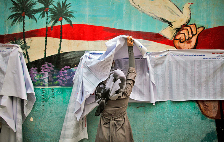24 hours in pictures: A voter checks her name before casting her vote during Egypt's election