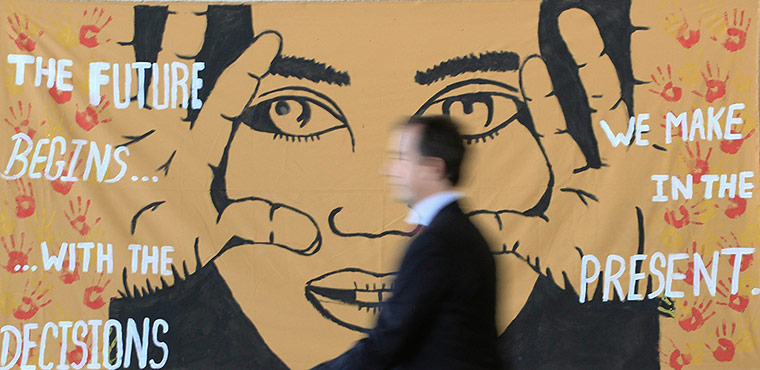 UN Rio+20: Man walks past a banner at the entrance of the of the Brazil Pavilion