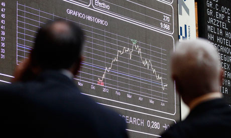 Traders look at computer boards at the stock exchange in Madrid