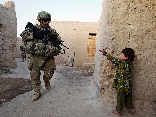 24 Hours: A girl gestures to Francisco Valderrama, a U.S. Army Sergeant, on patrol