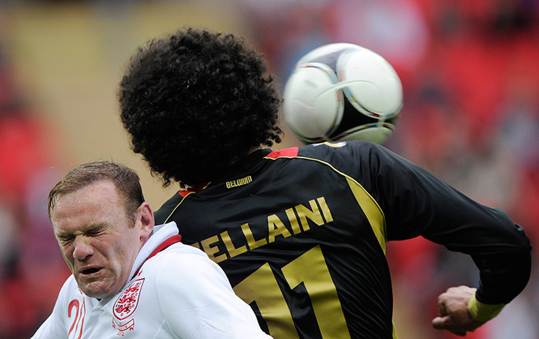 ENGLAND V BELGIUM: Wayne Rooney feels the force of Marouane Fellaini