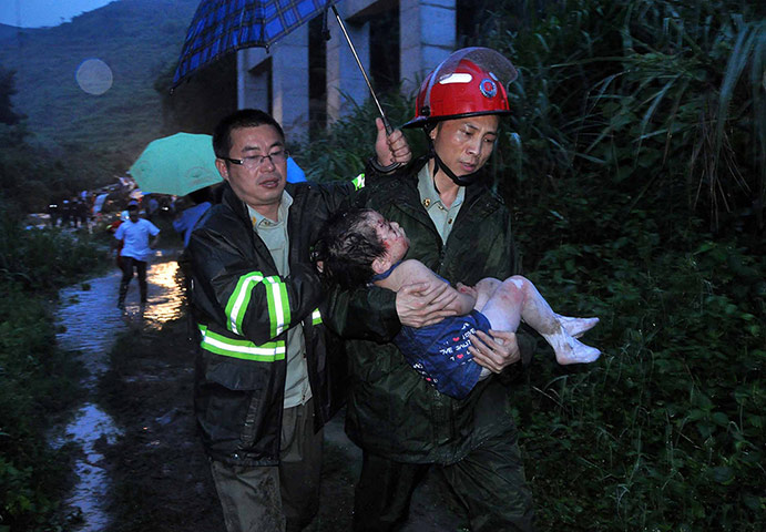 Picture desk live: A firefighter carries a young child