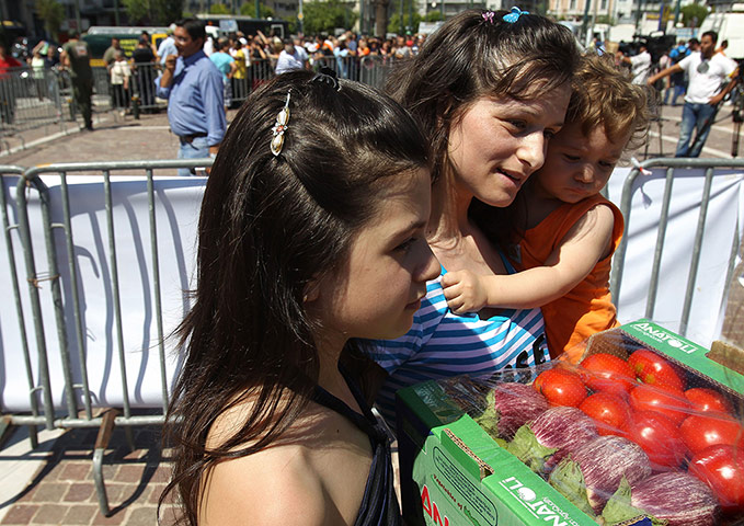 Picture desk live: A mother and her children carry a box of vegetables