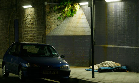 A homeless person sleeps rough under a bridge in central London