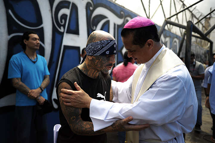 24 hours in pictures: Catholic priest speaks with a member of Mara Salvatrucha gang 