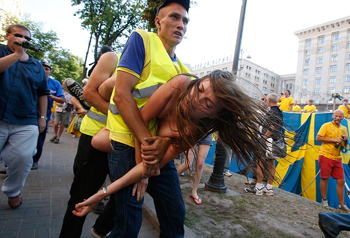 24 hours in pictures: A protester from Ukrainian women rights  group Femen is carried away